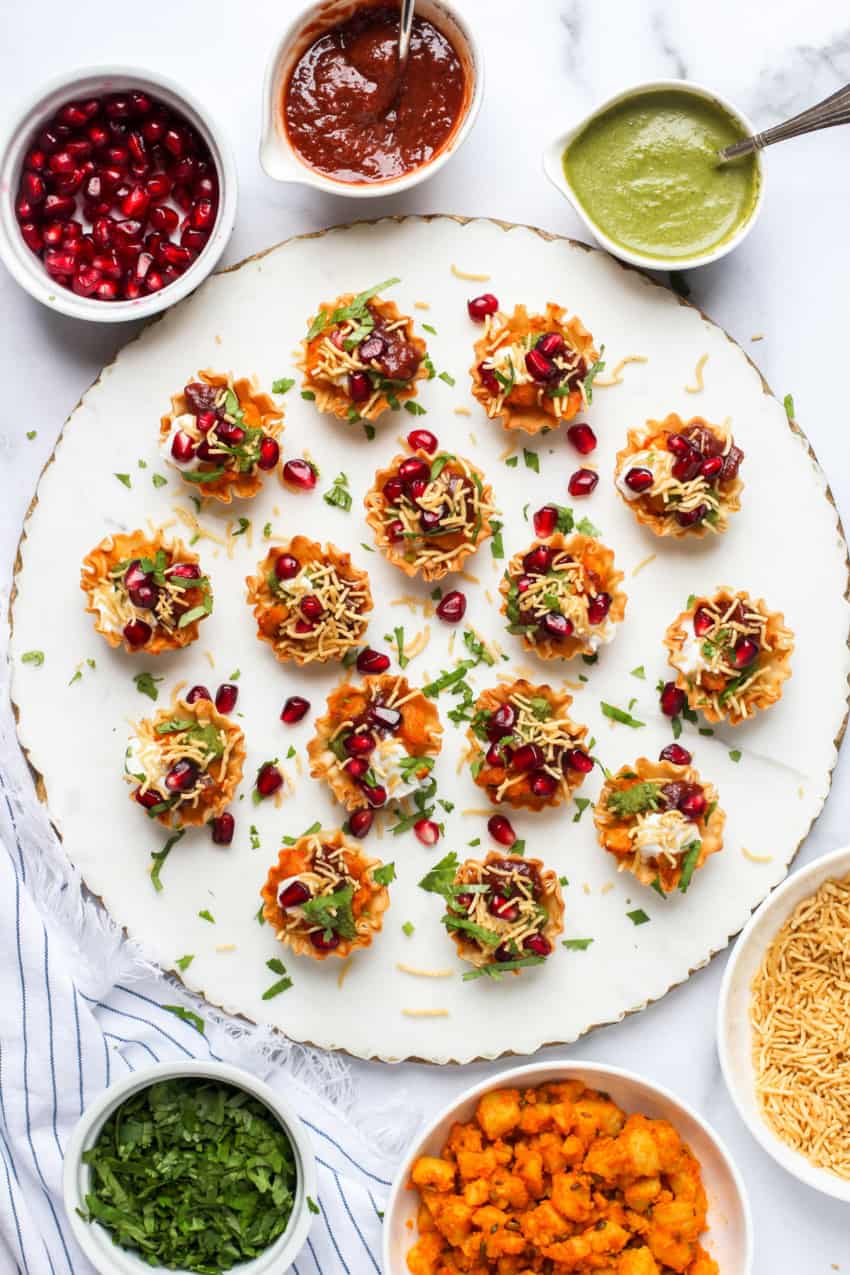 Aloo Chaat served on a marble board with garnishes on the side