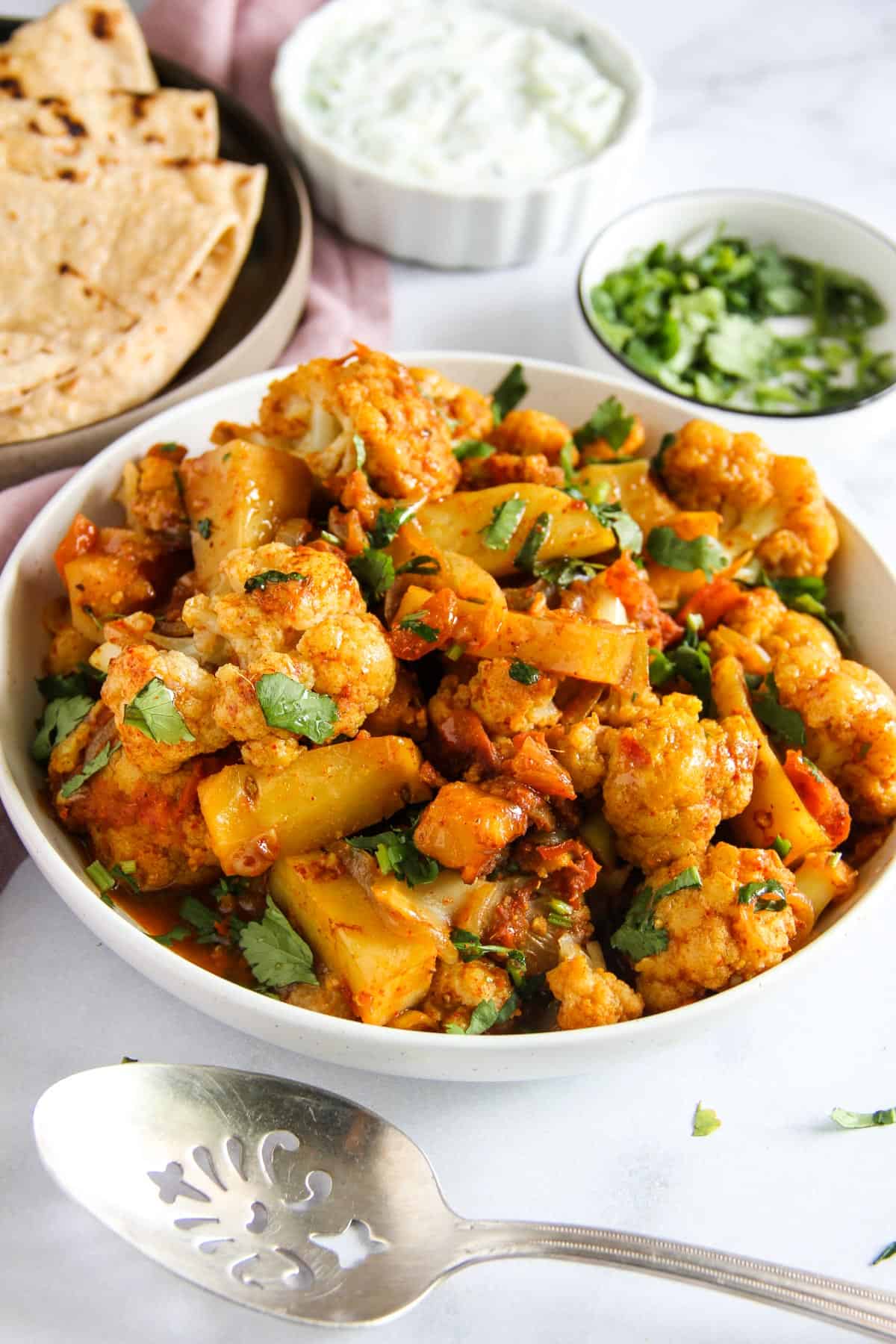 potato and cauliflower stir fry served with roti and raita