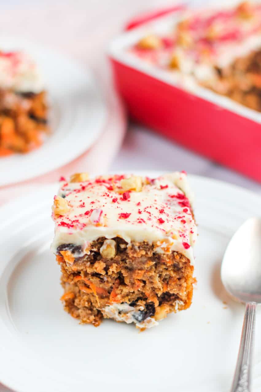 carrot cake with frosting on a white plate 