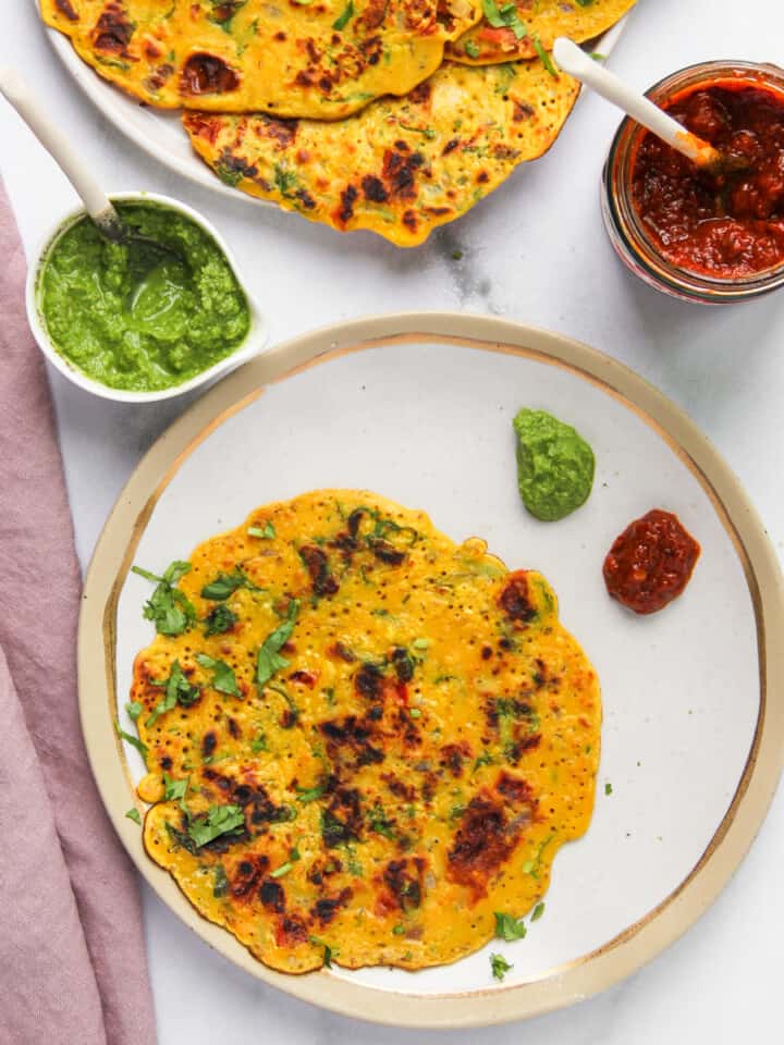 besan chilla served with cilantro mint chutney and pickles