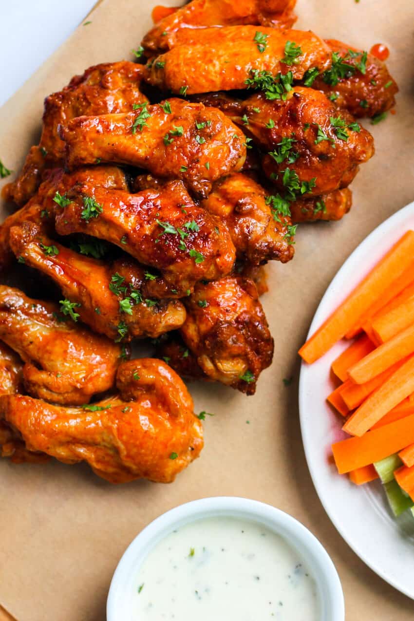 A plate of air fryer buffalo chicken wings with carrot sticks
