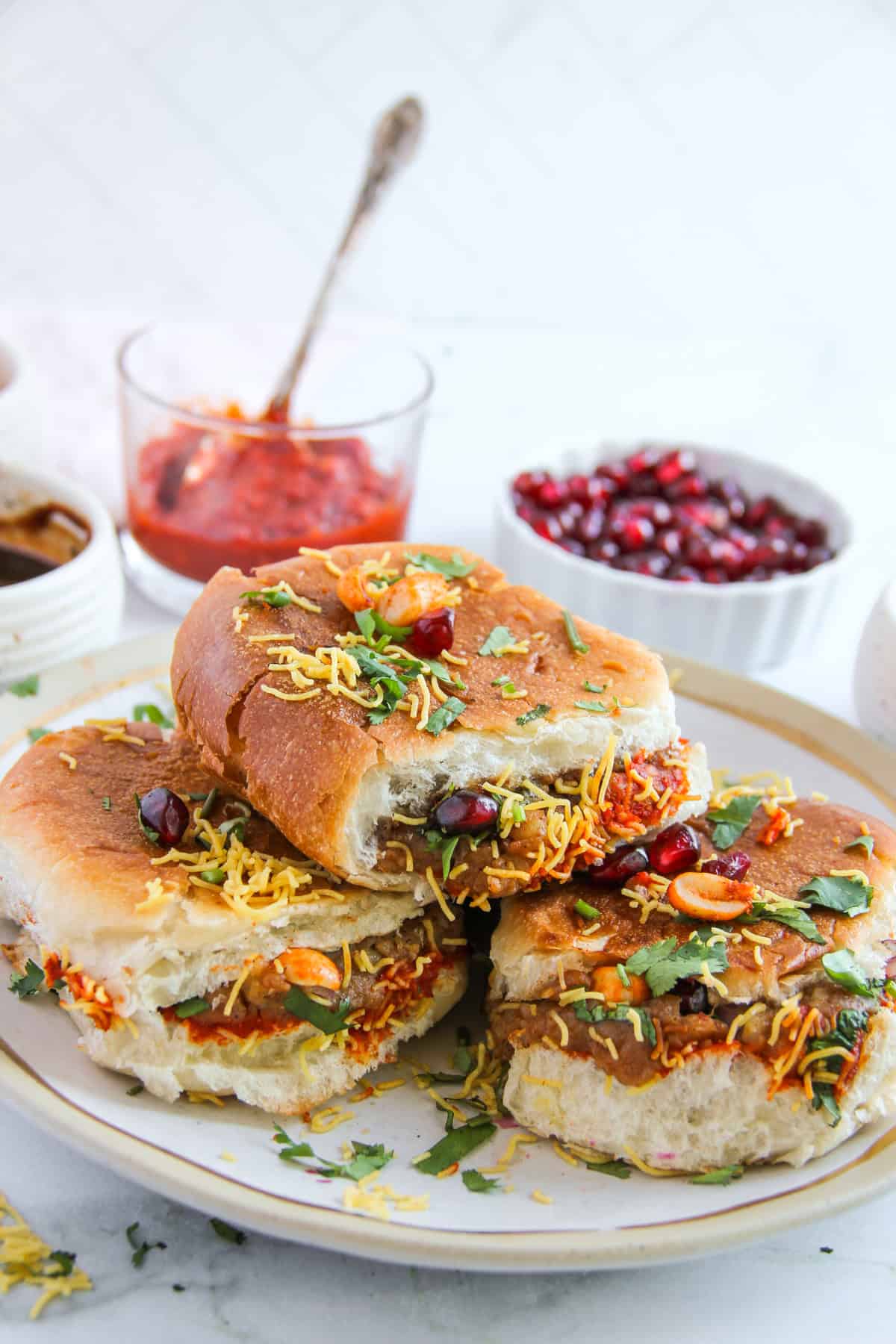Dabeli served in a platter garnished with sev, cilantro an d pomegranate arils 
