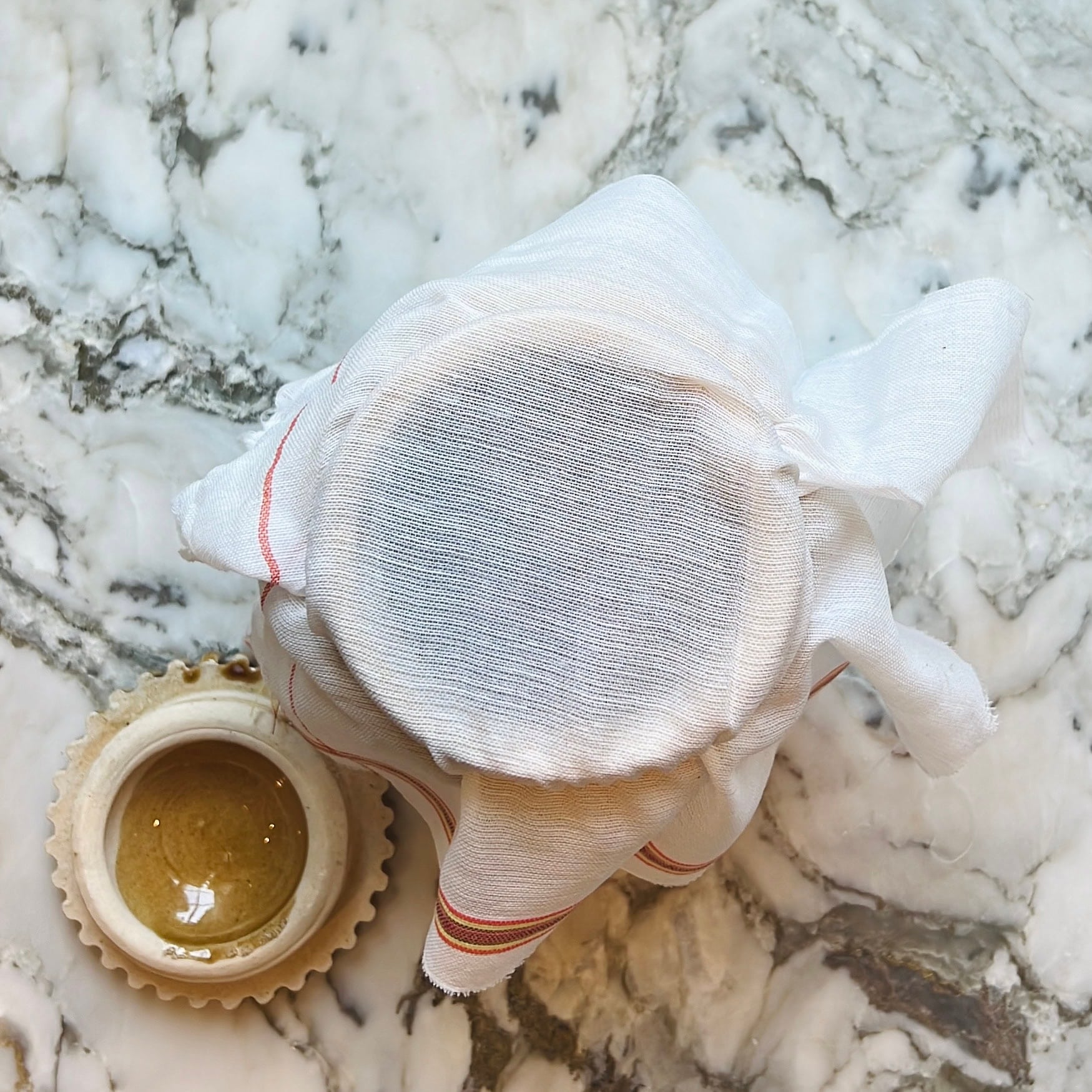 pickle jar covered with cheese cloth.