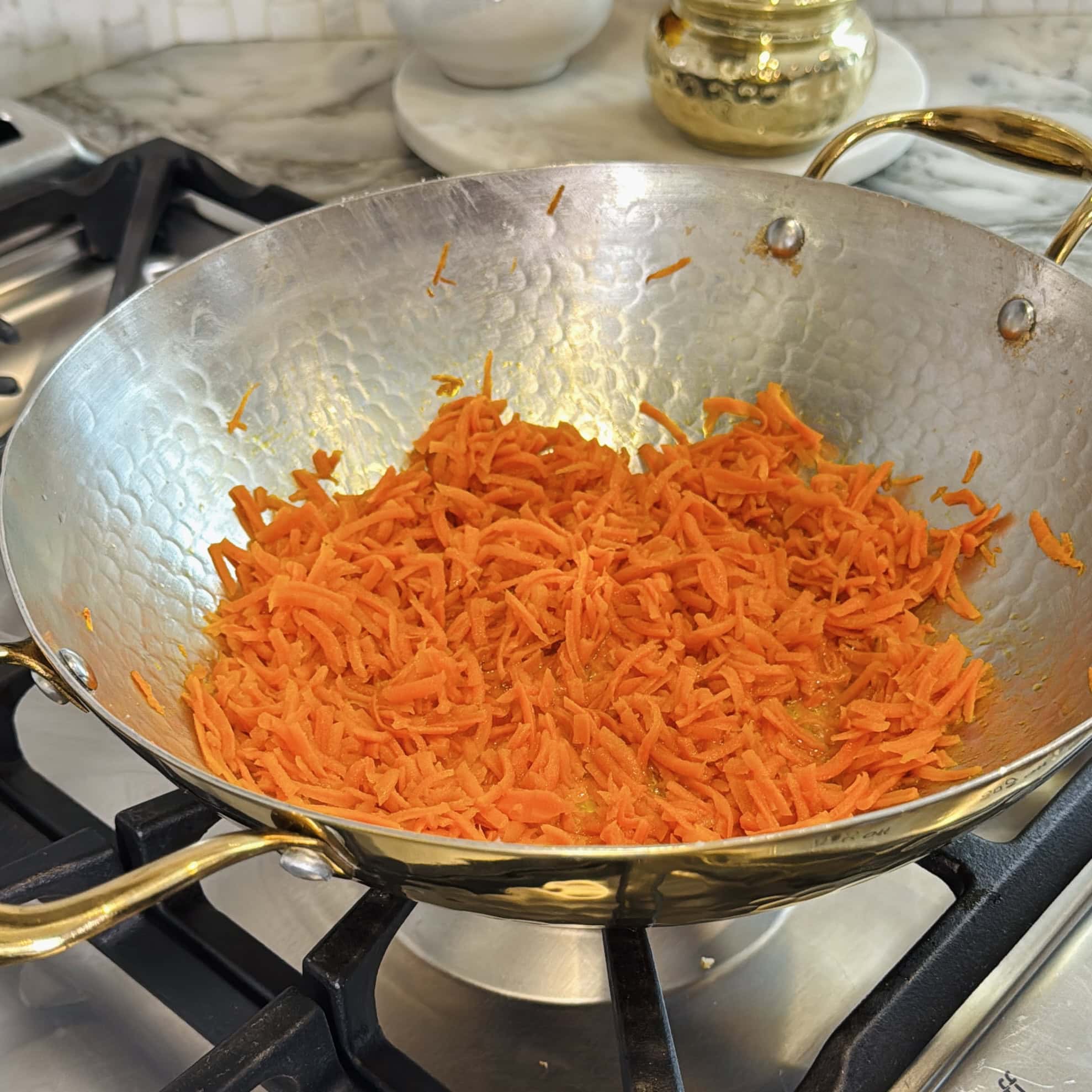 roasting grating carrots in a pan.