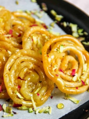 Jalebi garnished with pistachions and rose petals