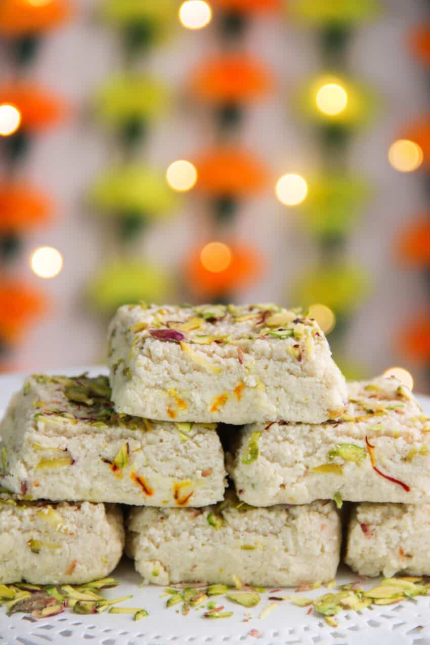 stack of kalakand cubes with a festive back drop 
