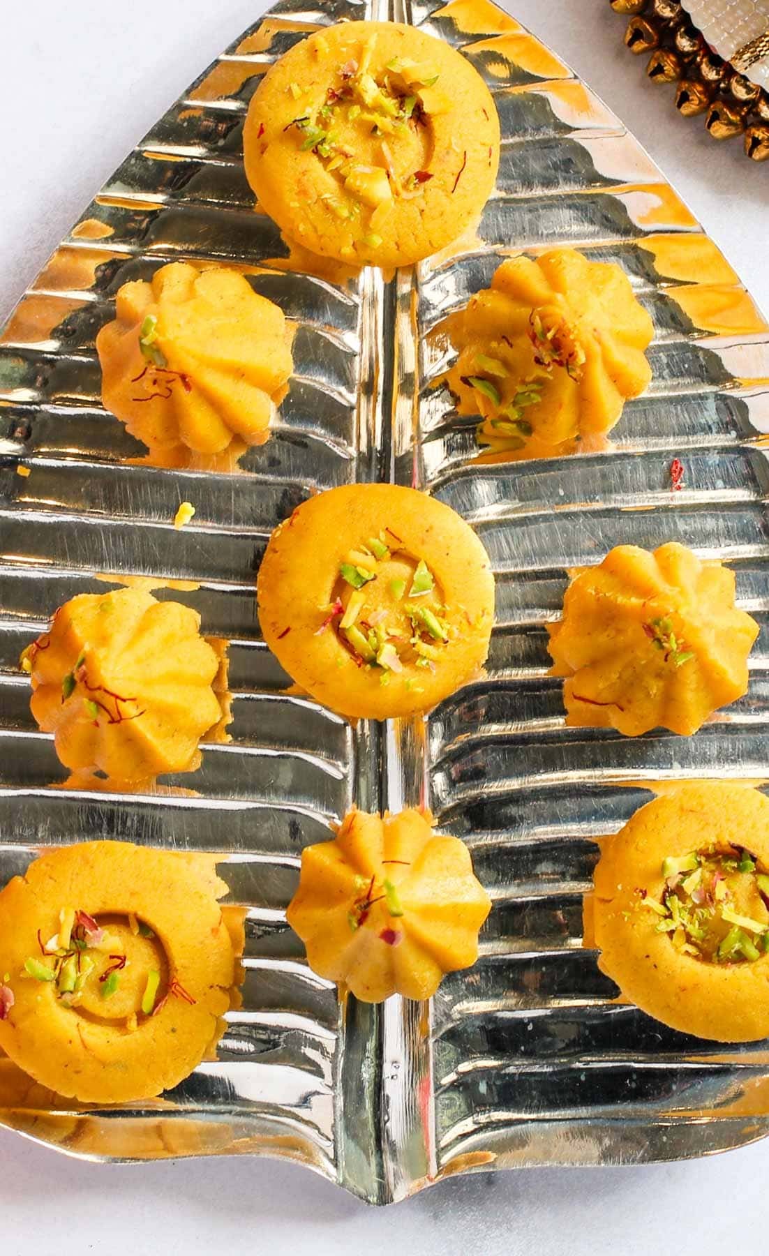 Kesar malai modak and peda in a silver platter.