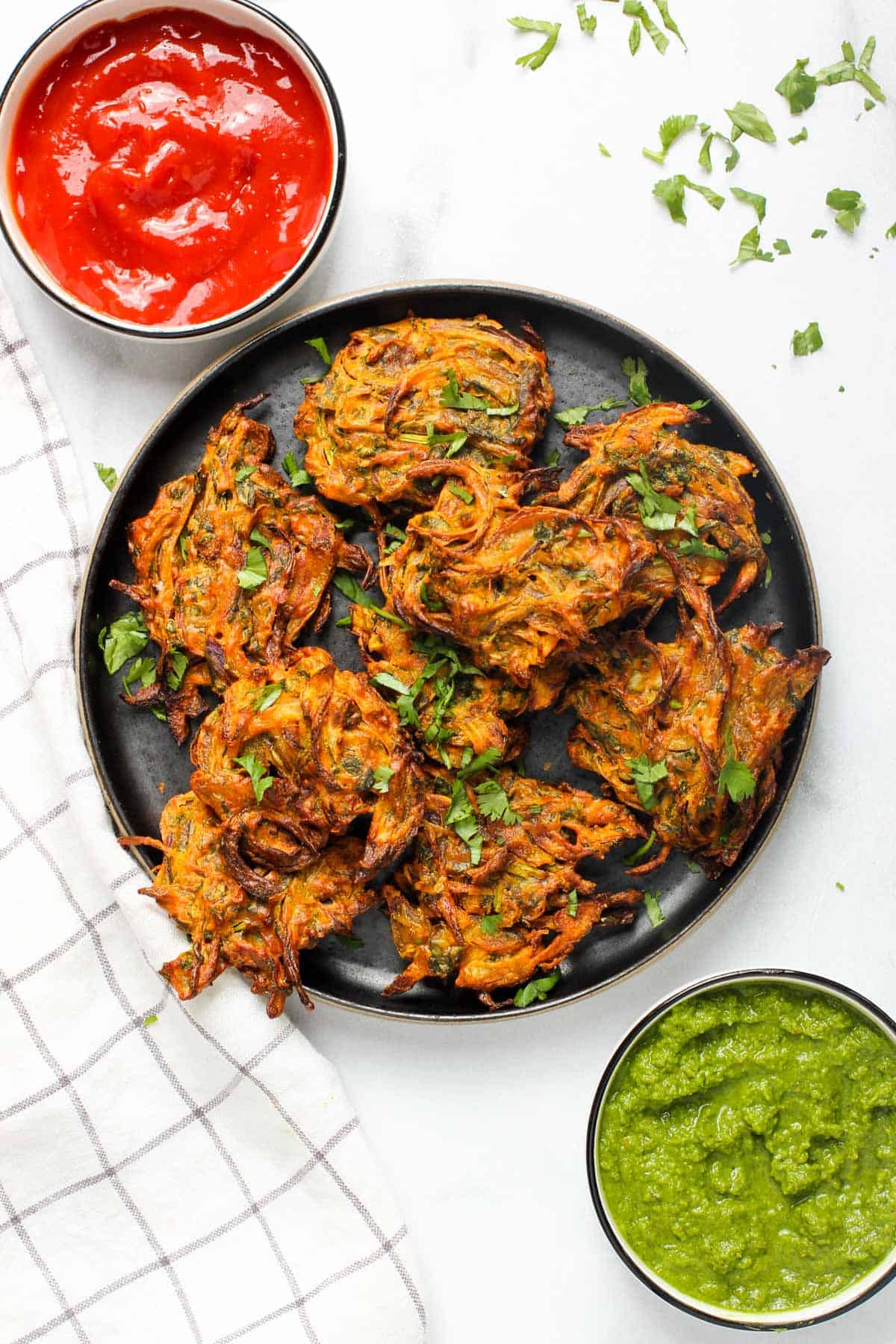 Onion pakodas served with ketchup and cilantro mint chutney