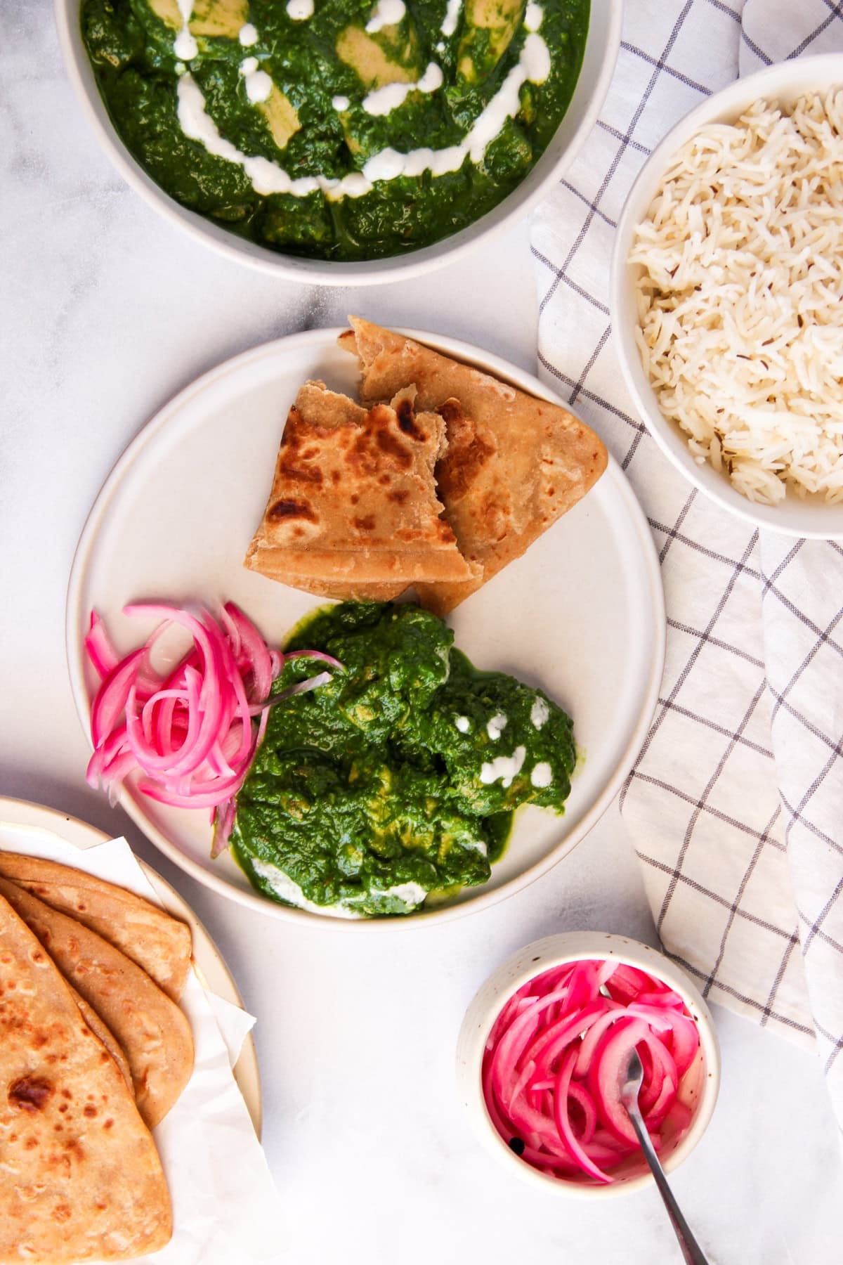 palak chicken served with paratha and pickled onions