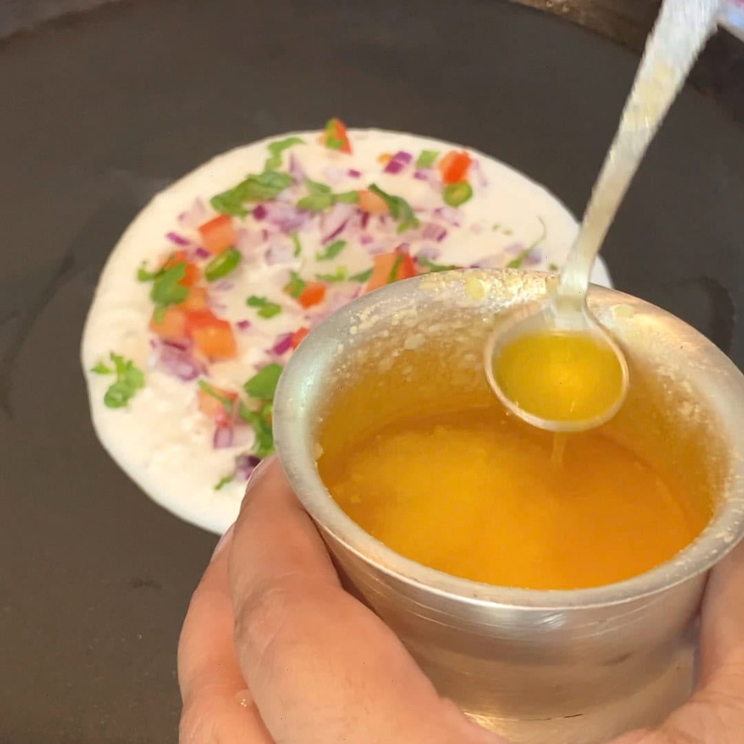 adding ghee to uttapam