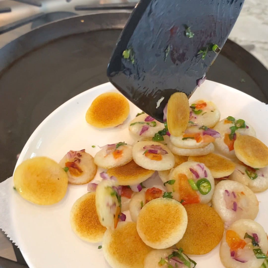 taking out bite sized uttapam from the pan