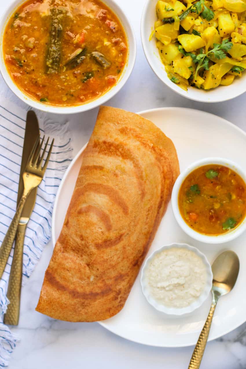 quinoa dosa served with sambar, chutney & curried potatoes