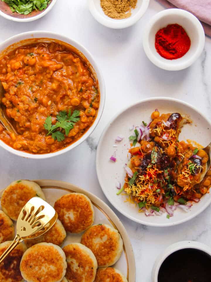 ragda patties served in a white plate with a bowl of curry on the side.