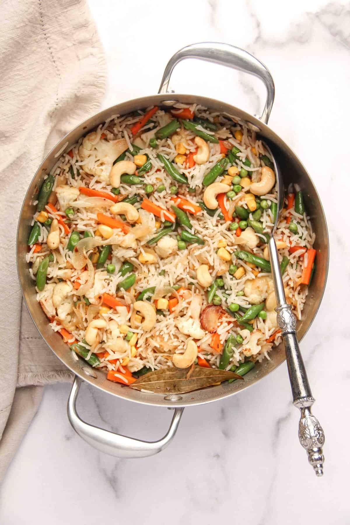 Veg Pulao in a pan with serving spoon